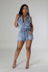 Détail d'un combishort en jean bleu clair avec boutonnage et ceinture à la taille