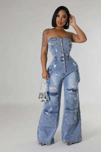 Gros plan sur une combinaison cargo en jean bleu clair avec boutons et détails déchirés