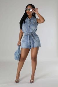Détail de combishort en jean bleu clair avec boutons en métal et taille à cordon serrage