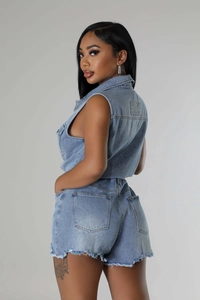 Détail du gilet en jean bleu clair et du short délavé avec bords effilochés