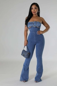 Close-up of denim jumpsuit showing tube top with large metal buckle and waist cutout detail