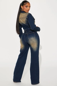 Rear view of slim fit denim jumpsuit featuring vintage sand wash finish on back and hips
