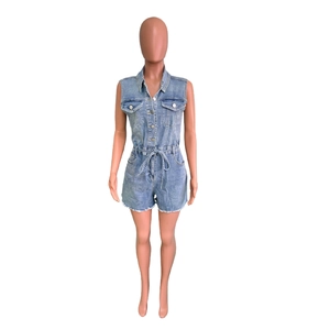 Détail du combishort en jean bleu clair avec boutons en métal et ourlet effiloché