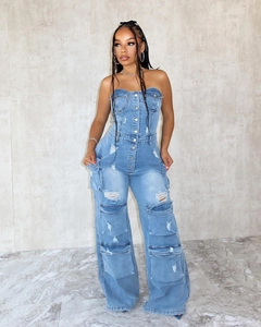 Détail d'une combinaison bustier en jean avec textures déchirées et poches cargo
