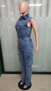 Detail of blue denim jumpsuit featuring a drawstring waist and distressed hemline