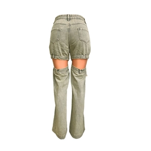 Détail macro du jean vintage vert à taille haute avec découpes et poches arrière uniques