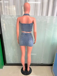Rear view of washed blue denim two-piece set with cross embroidery detail and back pockets