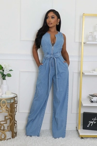 Detail of light blue denim jumpsuit featuring silver front zipper and tied waist belt