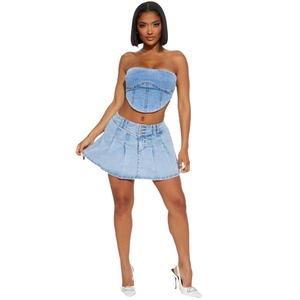 Détail d'un ensemble deux pièces en denim délavé avec haut corset et mini-jupe plissée