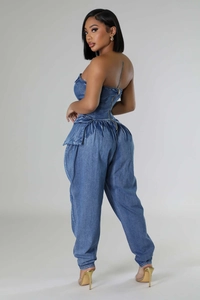 Detail view of denim tube top jumpsuit featuring a ruffled waist and back zipper design