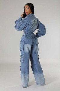 Back view of cargo denim jumpsuit with large pockets and washed finish in studio lighting