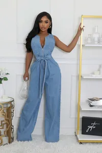 Close-up of light blue wash denim jumpsuit showing front zipper and waist tie belt