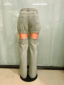 Détail du pantalon en jean vintage délavé avec découpes superposées et coupe droite