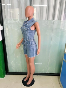 Détail d'un combishort en jean délavé avec taille à cordon et ourlet à franges