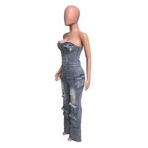 Détail de combinaison en jean avec poches cargo et finition délavée effet usé