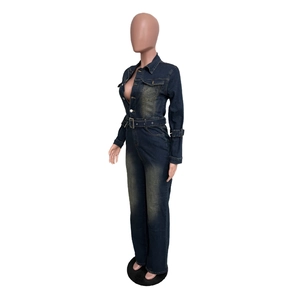 Detail of slim fit denim jumpsuit featuring button closure and metallic buckle belt