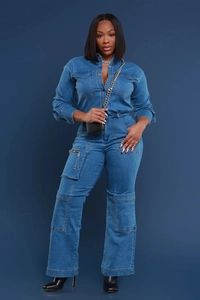 Detail of loose denim jumpsuit with chest pockets and utility cargo zippers on flared legs
