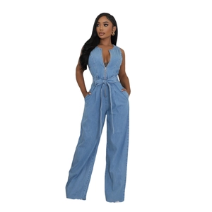 Detail view of denim jumpsuit featuring a metal front zipper and waist belt tie