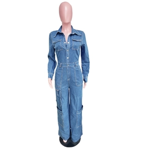 Detail of blue denim jumpsuit showing classic collar, chest pockets, and button closure