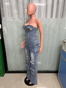 Détail d'une combinaison bustier en jean bleu avec poches cargo et déchirures usées