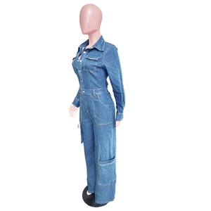 Detail of blue denim jumpsuit featuring classic collar, cargo pockets, and cinched waistline