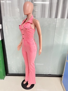 Dettaglio di una tuta cargo in denim rosa con scollo all'americana e bottoni in metallo