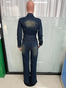 Detail view of denim jumpsuit back with washed effect, flare leg, and waist belt feature