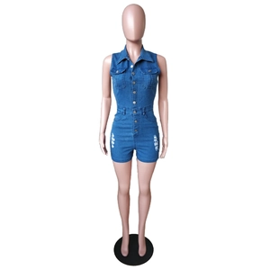 Detail of slim fit denim jumpsuit with button closure and ripped distressed texture