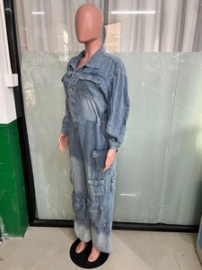 Detail of light blue washed denim cargo jumpsuit with multi-pockets and buttoned front