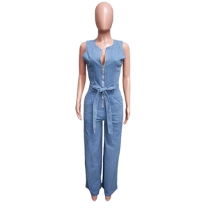 Detail of light blue denim jumpsuit featuring a metal zip front and matching waist tie