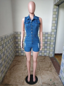 Close-up of distressed denim romper details with chest pockets and metal buttons