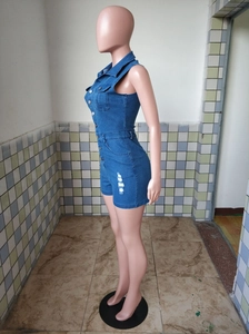 Detail of distressed denim romper with metal buttons and frayed hem on slim-fit jumpsuit