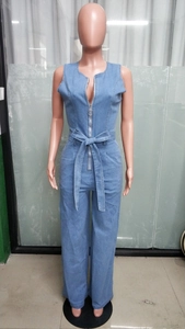 Detail of light blue denim jumpsuit featuring a V-neckline with metal ring zipper pull