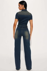 Rear view of dark blue denim jumpsuit showing slim fit waist and faded wash details