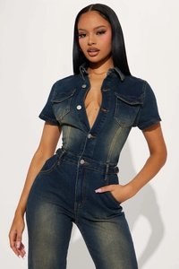 Close-up of vintage blue denim jumpsuit showing metal buttons and chest pocket details