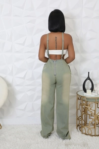 Detail view of the back zipper and adjustable straps on light green denim jumpsuit