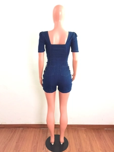 Vue arrière du combishort en jean bleu foncé avec détails plissés et bordures perlées blanches