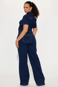 Rear view of dark blue denim jumpsuit with white contrast stitching and wide leg cut