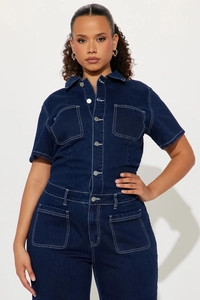 Detail of dark blue denim jumpsuit with contrast white stitching and metal button closures