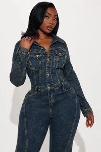 Detail of acid wash denim jumpsuit featuring metal buttons and dual flap chest pockets