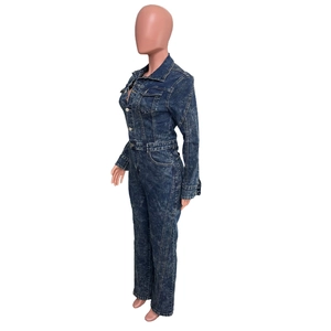 Detail view of the deep blue acid wash denim texture and metal buttons on this jumpsuit