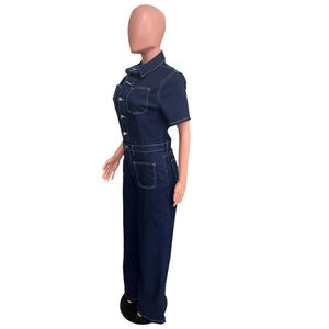 Side view of dark blue denim jumpsuit with contrast stitching and chest pockets
