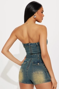 Dettaglio della zip posteriore e vita alta su una tuta in denim lavato stile vintage