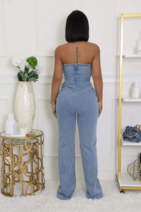 Vista posteriore di una tuta di jeans senza spalline con vita alta e zip nascosta