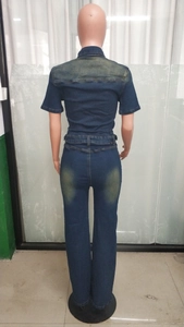 Detail view of the back of a slim fit dark blue denim jumpsuit with waist stitching