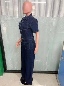 Detail view of dark blue denim jumpsuit with contrast stitching on pink mannequin