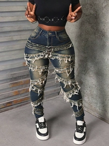Détail d'un jean skinny taille haute avec des franges en spirale et des bords effilochés