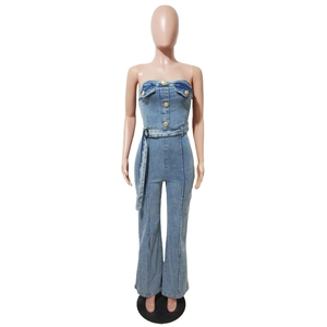 Dettaglio della tuta in denim senza spalline con bottoni dorati e cintura coordinata