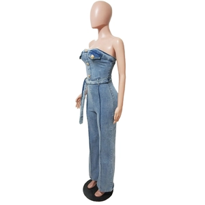 Dettaglio della tuta in denim senza spalline con bottoni dorati e cintura in vita