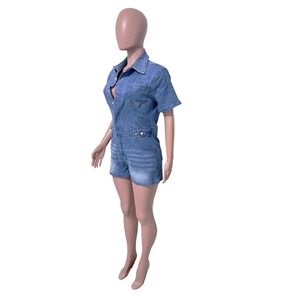 Close-up of blue washed denim short jumpsuit with lapel collar and single chest pocket